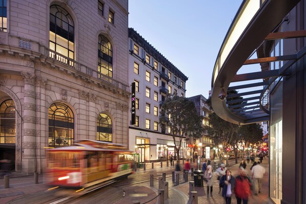 A street scene with a tram, pedestrians, and historic buildings. - Axiom Hotel (San Francisco)