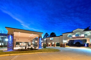 A large, multi-story building with a covered entrance and a well-lit driveway. - Holiday Inn Express Show Low by IHG (Show Low)