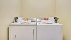 Two white front-loading washing machines with Tide and Bounce detergent boxes on top. - Day Star Dallas South (Dallas)