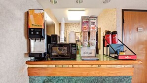 A hotel reception area with a coffee machine, microwave, and various beverage dispensers. - Day Star Dallas South (Dallas)