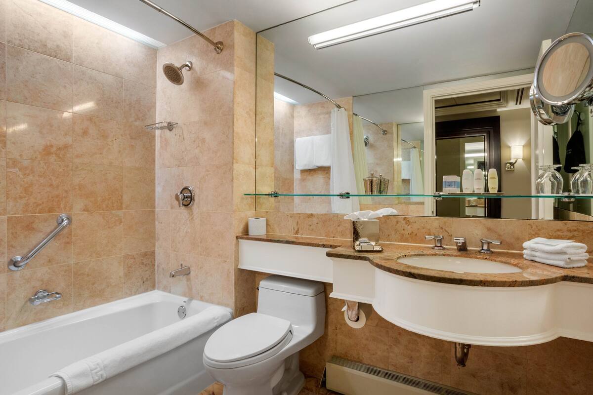 Uma casa de banho moderna com banheira, sanita e lavatório.
