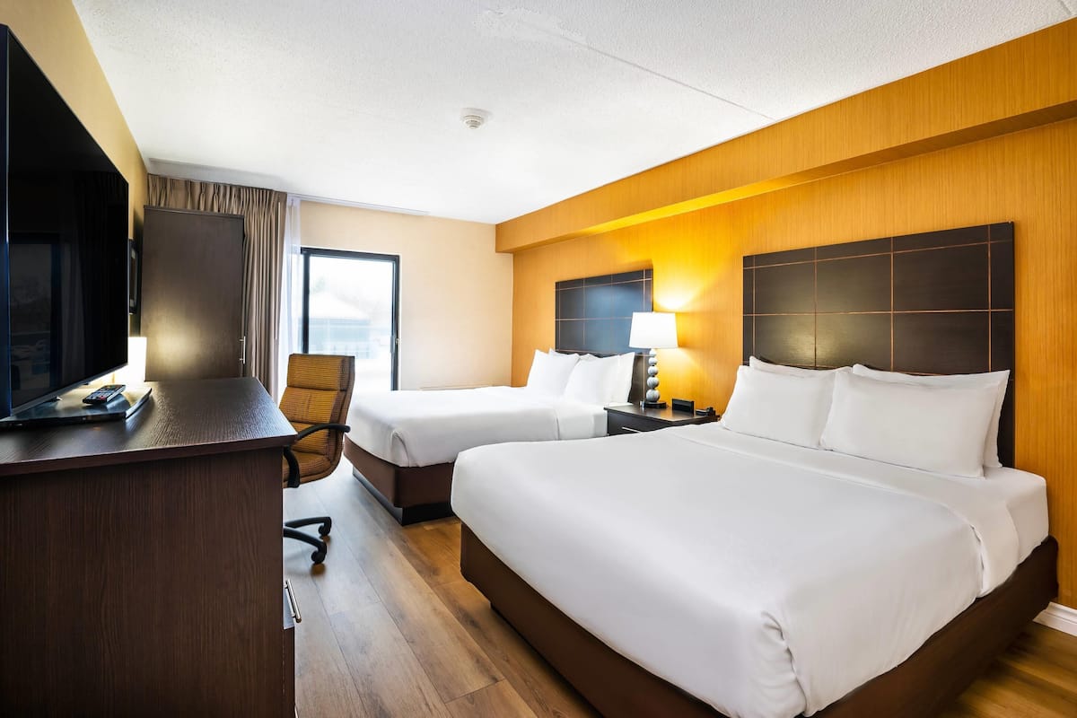 Room, 2 Queen Beds, Non Smoking (Dog Friendly) Ground Level | Una scrivania, tende oscuranti, ferro/asse da stiro