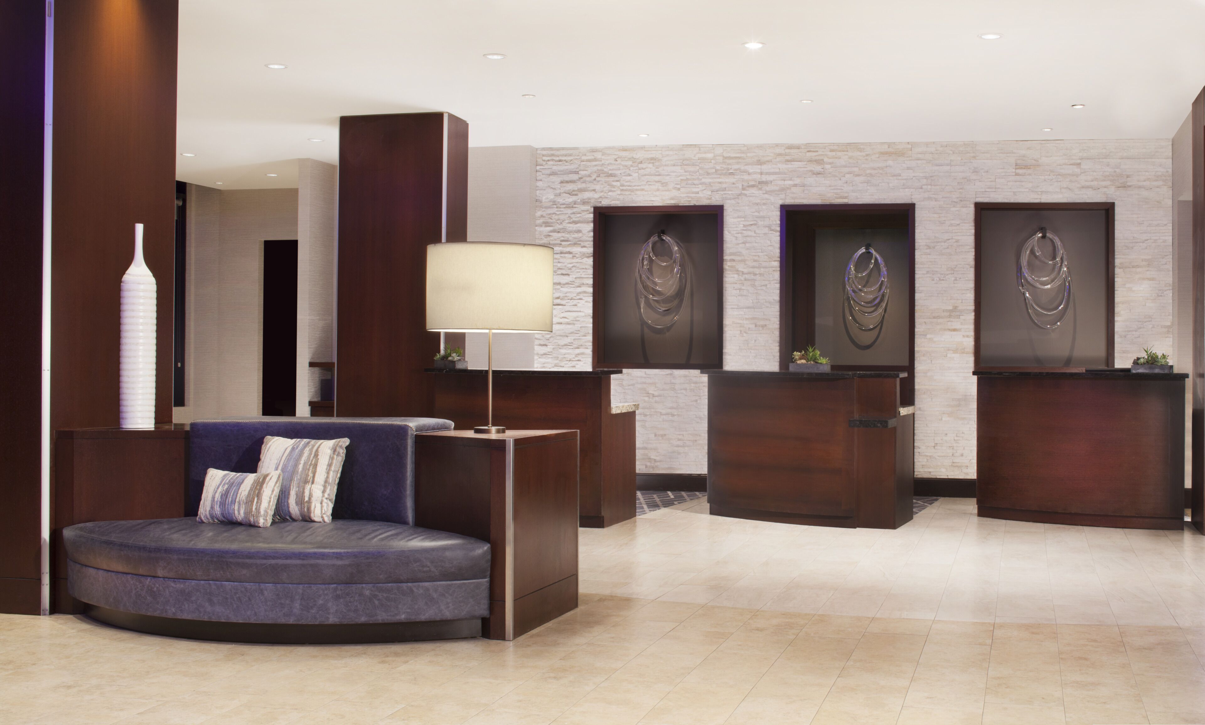 A modern reception area with a curved seating area, a reception desk, and decorative wall art.