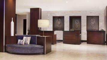 A modern reception area with a curved seating area, a reception desk, and decorative wall art.