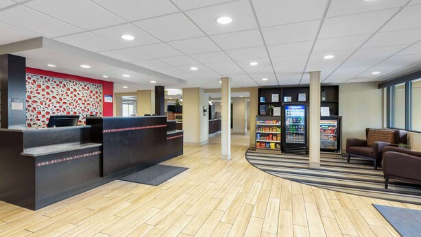 A reception area with a check-in counter, a seating area with sofas, a vending machine, and a refrigerator. - Best Western Rochester Marketplace Inn (Rochester)