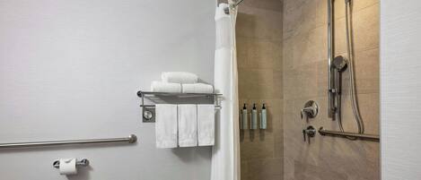 A modern bathroom with a shower, toilet, and towel rack.