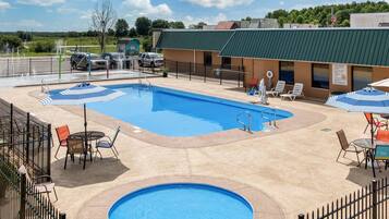 Relax by the pool surrounded by lounge chairs and umbrellas, with a table nearby for refreshments.