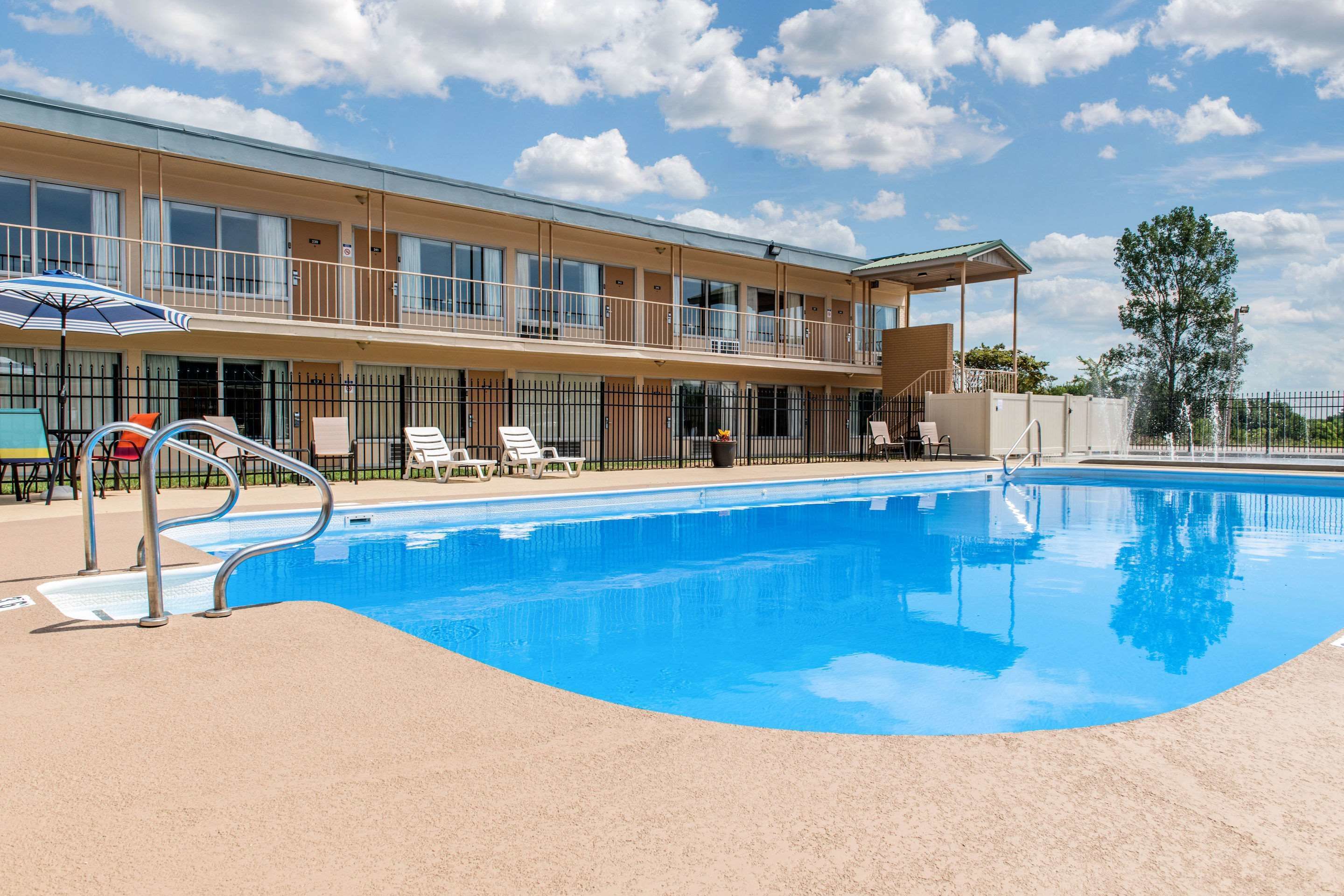 A swimming pool with lounge chairs and a covered seating area.