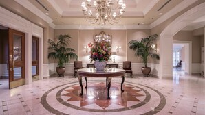 A lobby with a central round table, a chandelier, and potted plants. - The Sutton Place Hotel Vancouver (Vancouver)