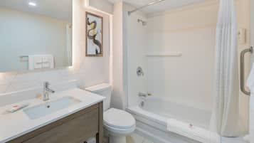 Un baño moderno con lavamanos, inodoro y ducha.