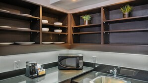 A modern kitchen with a built-in microwave, coffee maker, and a sink. - Comfort Inn Belleville (Belleville)