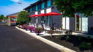 A building with outdoor seating, a flag, and a clear sky.