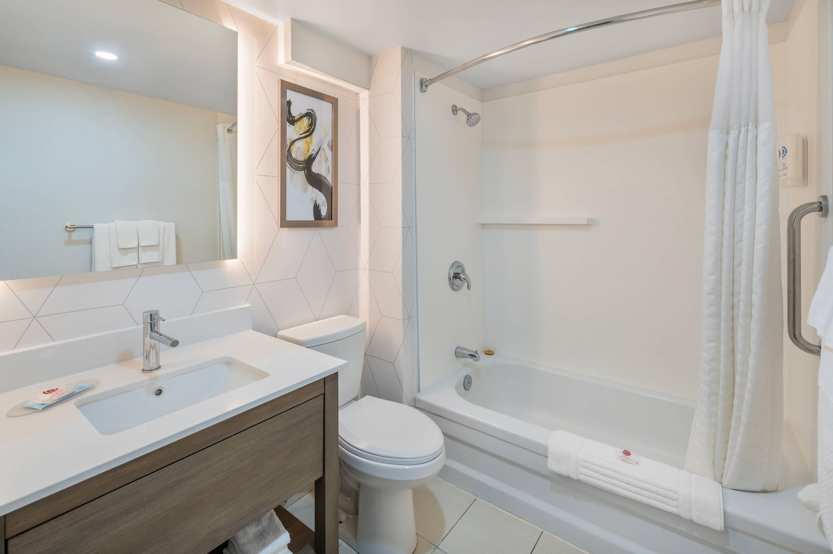 Un baño moderno con lavamanos, inodoro y bañera.