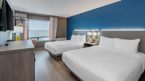 A hotel room with two beds, a desk, and a window with curtains. - Comfort Inn Belleville (Belleville)