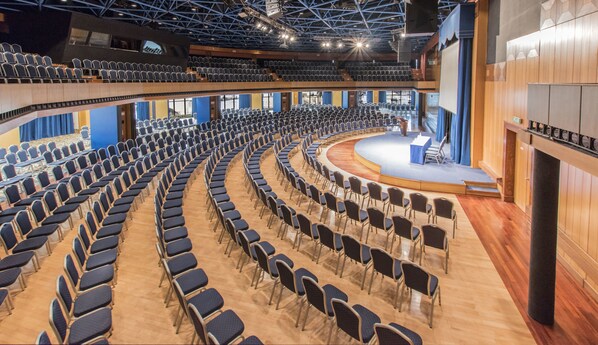 A large auditorium with rows of chairs and a stage. - DoubleTree by Hilton Malta (St. Paul's Bay)
