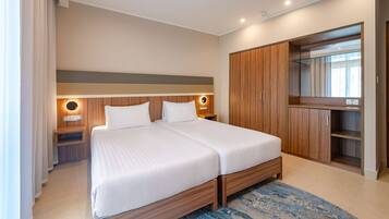 A double bed with a wooden headboard, bedside tables with lamps, a wardrobe, and a large mirror.