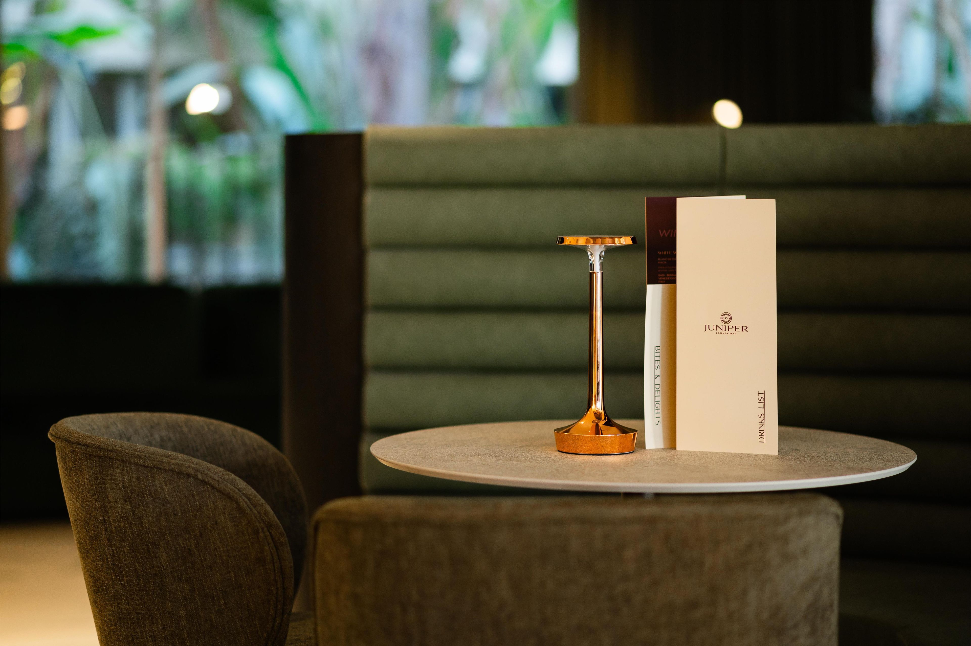 A round table with a menu, a menu stand, and a chair.