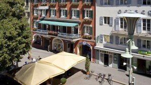 A hotel with multiple floors, balconies, and a central courtyard with outdoor seating.
