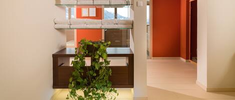 A hotel lobby with a glass display of towels, a green plant, and a sign indicating the exit.