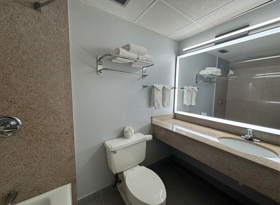 A modern bathroom with a toilet, sink, and towel rack.