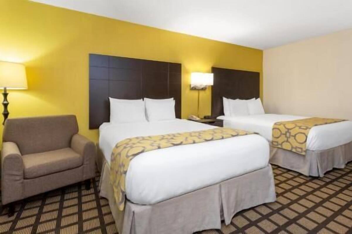Ein Hotelzimmer mit zwei Betten, einer Couch und einem gemusterten Boden.