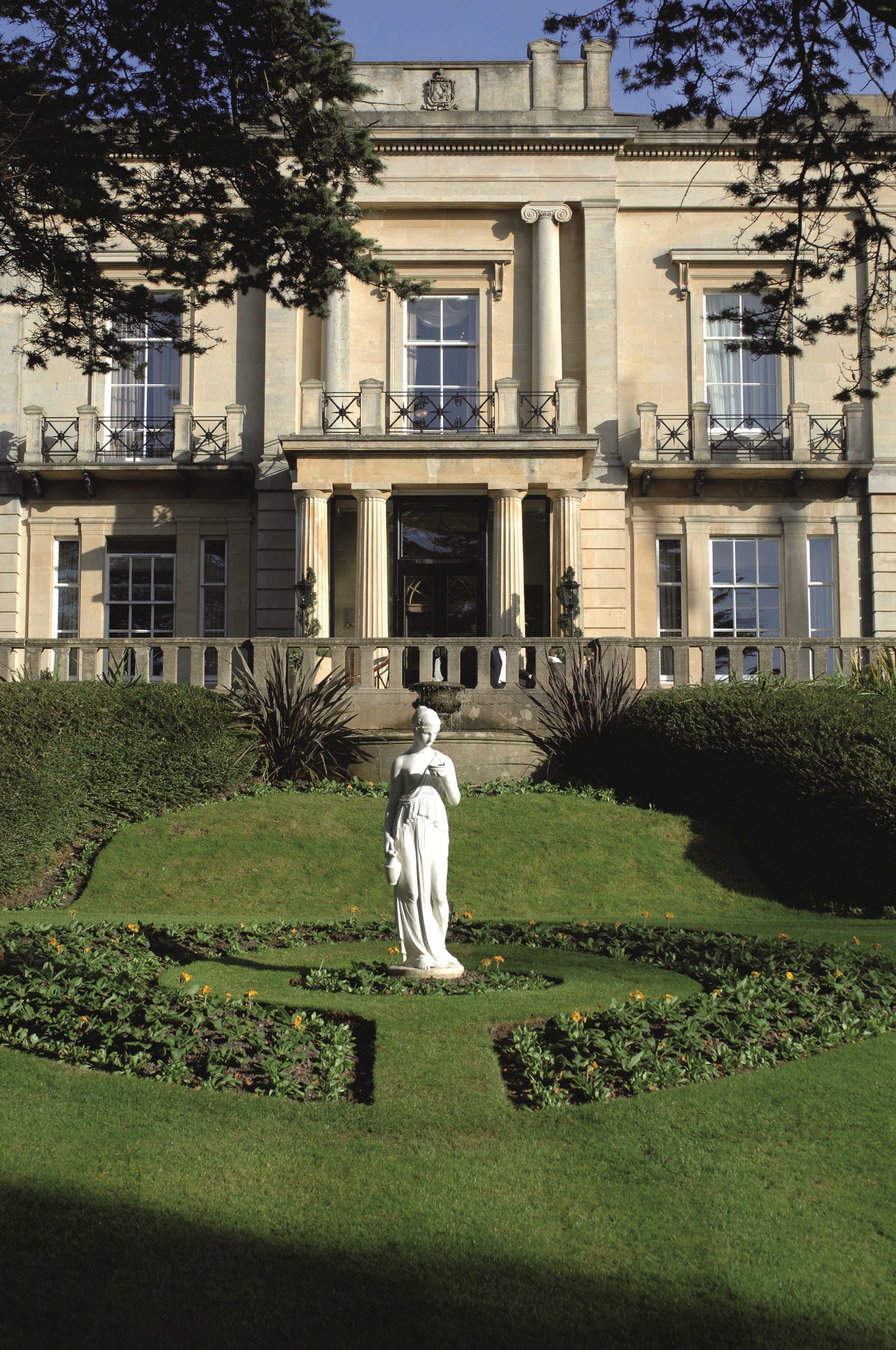 A stately building with a symmetrical facade, large windows, and a central entrance flanked by columns.