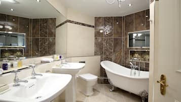 A modern bathroom with a freestanding bathtub, a double sink vanity, and a toilet.