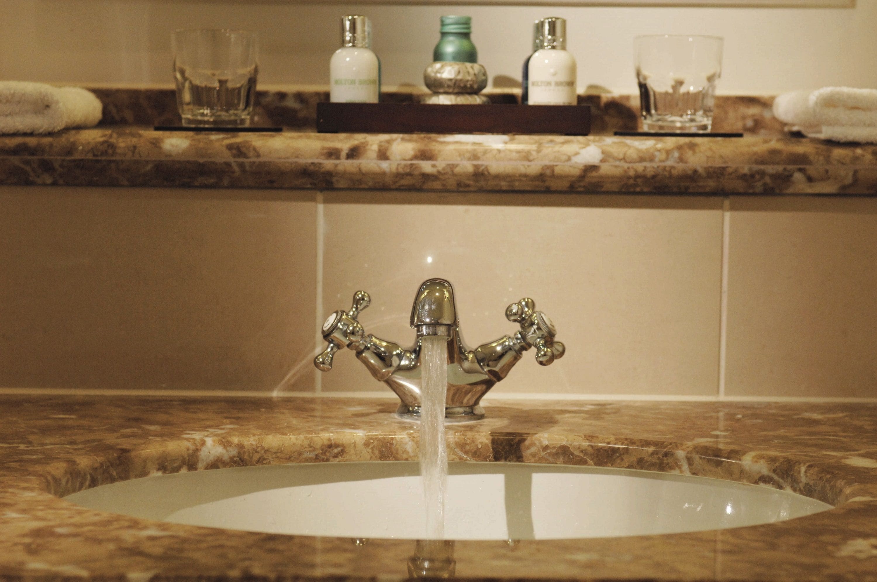 A bathroom sink with a decorative faucet and a marble countertop.
