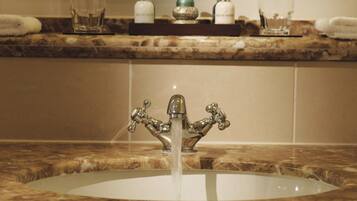 A bathroom sink with a decorative faucet and a marble countertop.