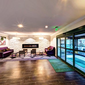 A lobby with a stone wall, seating area, and large windows.