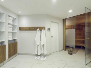 Une salle de bain moderne avec un espace douche, un porte-serviettes avec des serviettes et un meuble-lavabo en bois.