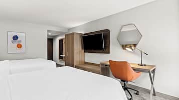 A hotel room with two beds, a desk with a chair, a TV, and a mirror.