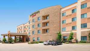 Un hôtel Courtyard by Marriott doté d’une façade en briques, de plusieurs étages et d’une entrée couverte.