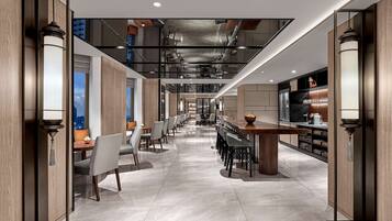 Eine moderne Hotelhalle mit einer langen Rezeption, einer Sitzgelegenheit und einer Bar.