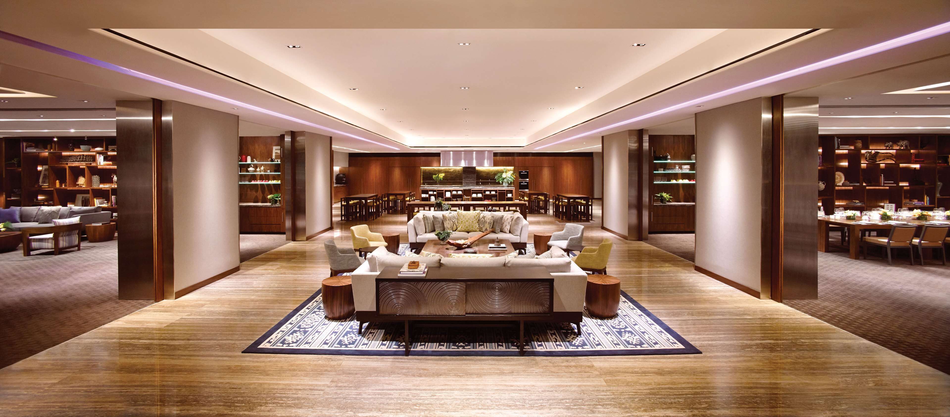 A spacious lobby with a central seating area, a dining area, and a well-lit ceiling with recessed lighting.