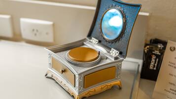 A vintage gramophone with a reflective surface and a decorative base, placed on a counter.