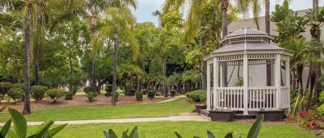 Un kiosque entouré d’une végétation luxuriante et de palmiers.