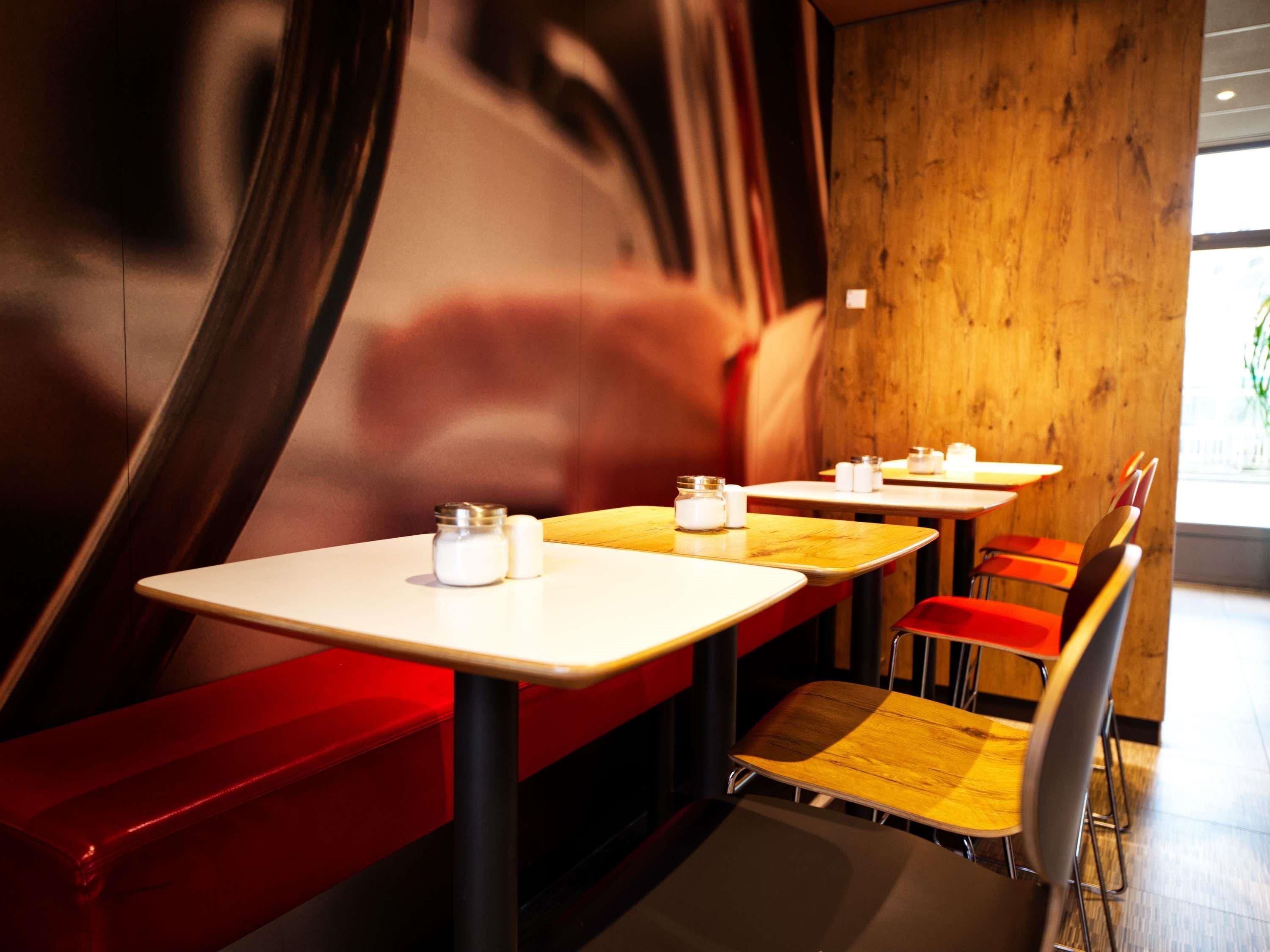 Un interior de restaurante con cabinas, mesas y sillas.