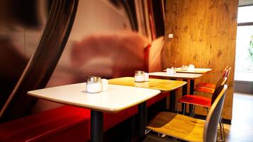 Un interior de restaurante con cabinas, mesas y sillas.