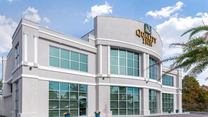 A modern building with a large sign reading "Quality Inn." It features multiple windows and a curved facade. - Quality Inn University North I-75 (Gainesville)