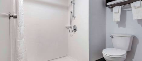 A bathroom with a white shower enclosure, a toilet, and a towel rack.