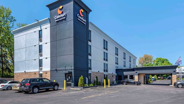 A Comfort Inn & Suites building with a modern design, featuring a prominent logo on the facade.