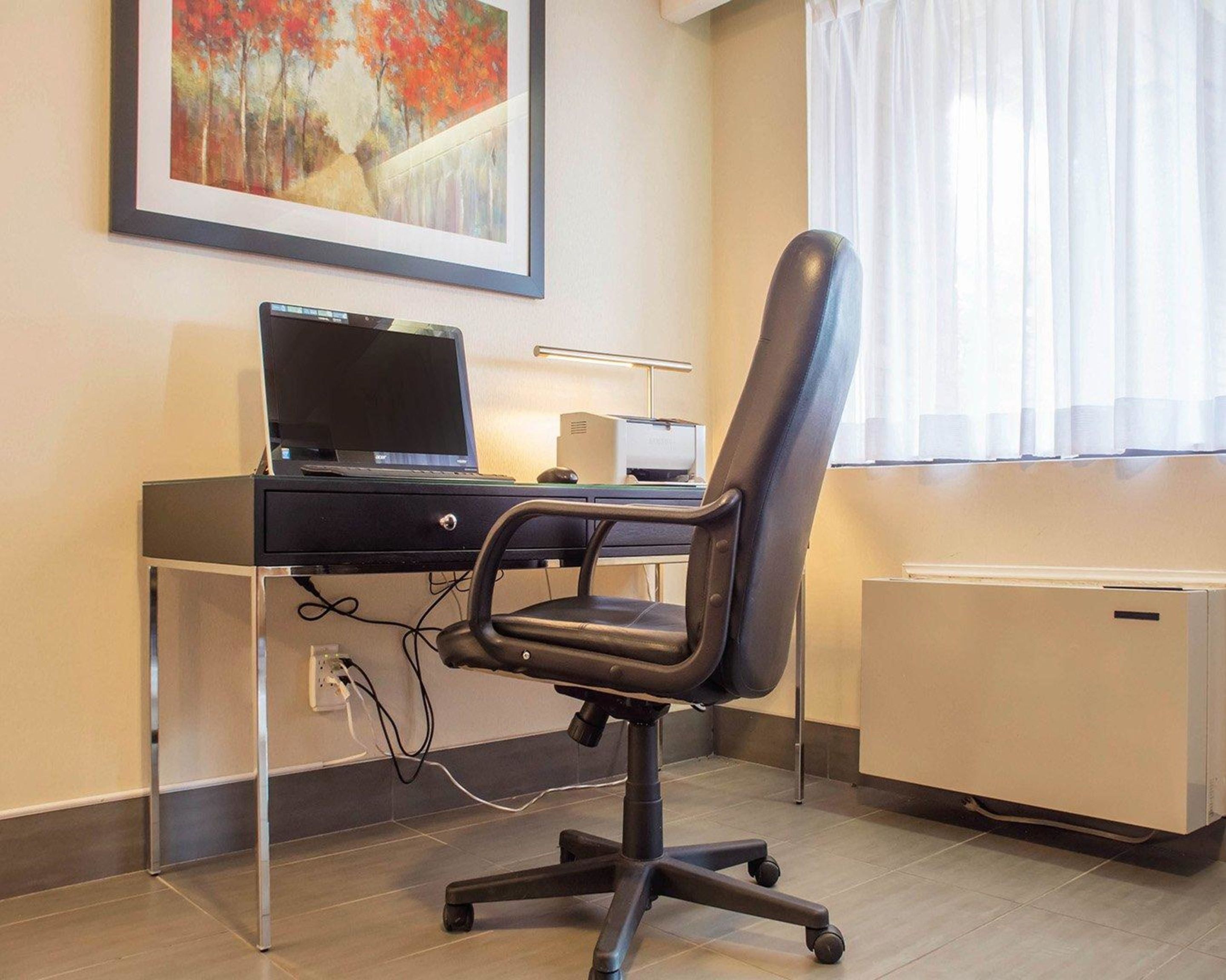 Un espacio de oficina moderno con escritorio, computadora y silla.