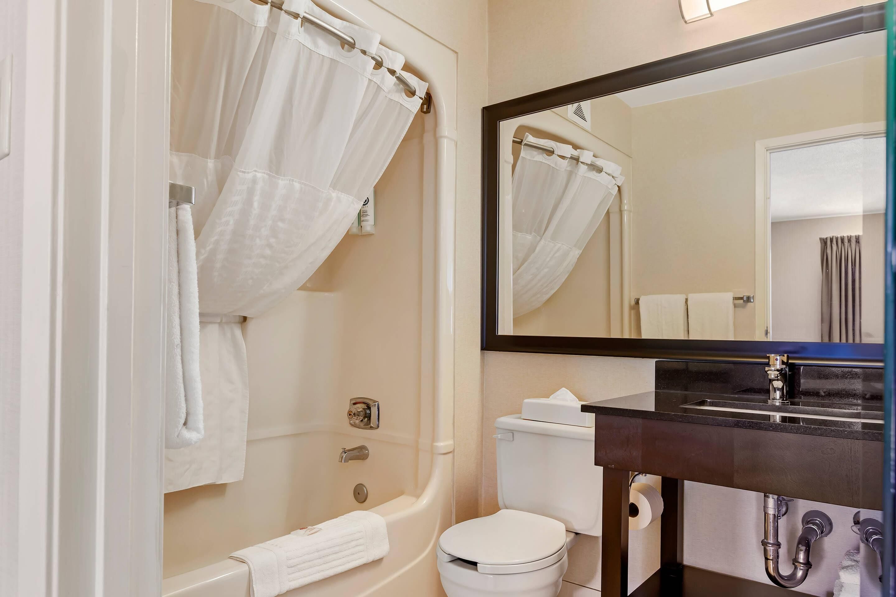 Un baño con bañera, inodoro y lavabo.