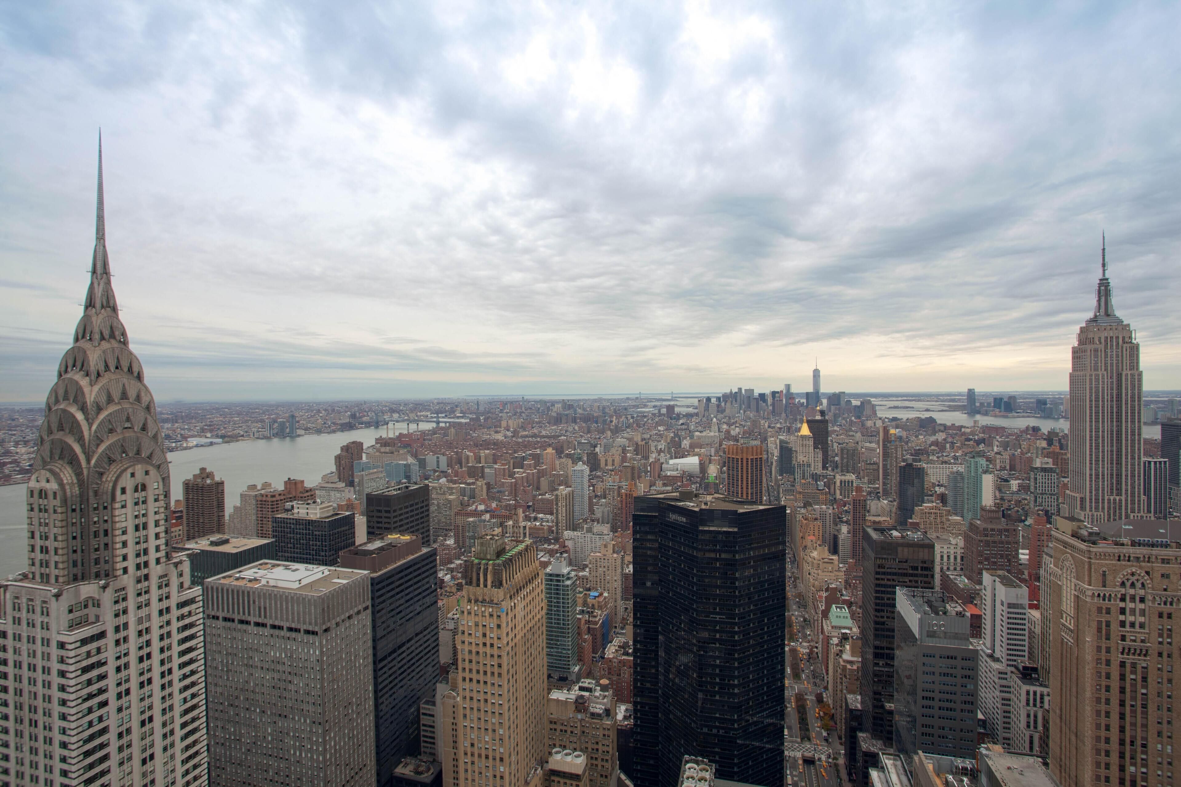 Pilvisen taivaan alla kohoava kaupunkikuva, jossa näkyvät selvästi korkeat pilvenpiirtäjät, kuten Chrysler Building ja Empire State Building.