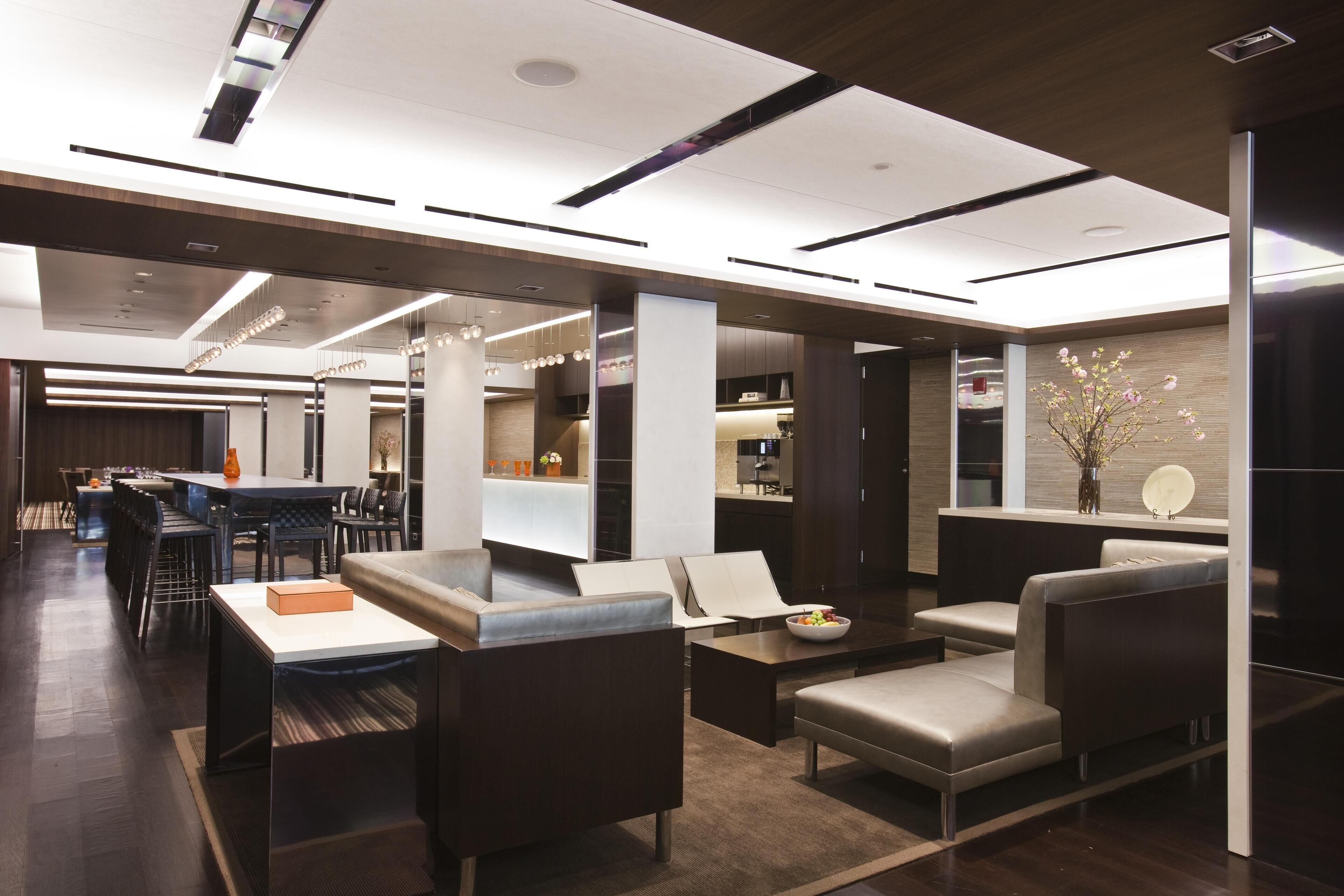 A modern hotel lobby with a bar area, seating, and a reception desk.