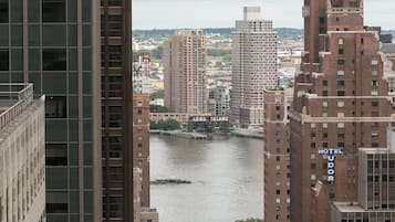 A high-rise hotel with a view of a river and other buildings.