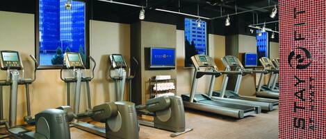 A fitness center with treadmills, elliptical machines, and stationary bikes.