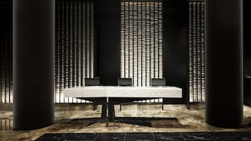 A modern conference room with a marble table, black chairs, and a patterned backdrop.