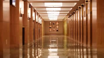 A long, polished hallway with wooden paneling and a series of wall-mounted lights.